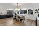 Dining area with a table, six chairs, and natural light streaming through large windows at 21632 W Hillcrest Blvd, Buckeye, AZ 85396