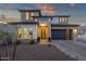 Beautiful home showcasing a modern design with desert landscaping, a gray garage door, and large windows at 21632 W Hillcrest Blvd, Buckeye, AZ 85396