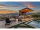 An outdoor seating area with a fire pit and outdoor bar, with mountain views at 21632 W Hillcrest Blvd, Buckeye, AZ 85396