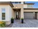 The front door features modern black framed glass, a covered entryway, and planters adding curb appeal at 21632 W Hillcrest Blvd, Buckeye, AZ 85396