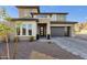 Stunning two-story home featuring modern architecture, a gray brick driveway, and low maintenance desert landscaping at 21632 W Hillcrest Blvd, Buckeye, AZ 85396