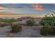 Picturesque desert landscape featuring native trees, shrubs, and a view of the mountains at sunset at 21632 W Hillcrest Blvd, Buckeye, AZ 85396