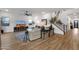 Open concept living room featuring neutral tones, wood floors, modern ceiling fan and staircase at 21632 W Hillcrest Blvd, Buckeye, AZ 85396