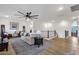Open living room featuring a large ceiling fan, hardwood floors, and neutral-toned furniture at 21632 W Hillcrest Blvd, Buckeye, AZ 85396