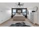 Modern main bedroom features an accent wall, stylish dresser, ceiling fan, and a natural cowhide rug at 21632 W Hillcrest Blvd, Buckeye, AZ 85396