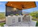 Well-equipped outdoor kitchen features a built-in grill, storage, a ceiling fan, and elegant countertop at 21632 W Hillcrest Blvd, Buckeye, AZ 85396
