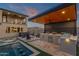 Beautiful backyard with an outdoor kitchen, pool, spa, and lush artificial grass at 21632 W Hillcrest Blvd, Buckeye, AZ 85396