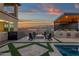 Backyard with an outdoor kitchen, fire pit, and lush artificial grass in a geometric design at 21632 W Hillcrest Blvd, Buckeye, AZ 85396