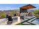 Outdoor kitchen with a built-in grill, bar seating, and a firepit for year-round entertaining under the covered patio at 21632 W Hillcrest Blvd, Buckeye, AZ 85396