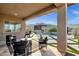 Covered patio offers a comfortable lounge space with views of the pool, outdoor kitchen and scenic mountains at 21632 W Hillcrest Blvd, Buckeye, AZ 85396