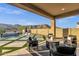Covered patio with sleek outdoor furniture offering a relaxing space with views of the pool and desert landscape at 21632 W Hillcrest Blvd, Buckeye, AZ 85396