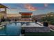 Backyard features a modern outdoor kitchen and pool with an attached spa, perfect for entertaining at 21632 W Hillcrest Blvd, Buckeye, AZ 85396