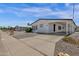 Charming single-story home features a white exterior, low maintenance landscaping, and covered carport at 2241 N Nicklaus Dr, Mesa, AZ 85215