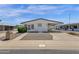 Charming single-story home features a white exterior, low maintenance landscaping, and covered carport at 2241 N Nicklaus Dr, Mesa, AZ 85215