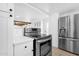 Bright kitchen featuring stainless steel appliances, white cabinets, and tile floors at 2241 N Nicklaus Dr, Mesa, AZ 85215