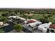 An aerial view reveals a residential neighborhood featuring a red-tiled roof, pool, and lush surroundings at 23002 N Country Club Trl, Scottsdale, AZ 85255
