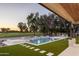 Backyard oasis with lush landscaping, a pristine pool, a spa, and a serene golf course view at 23002 N Country Club Trl, Scottsdale, AZ 85255