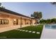 Beautiful backyard with a covered patio, pool, artificial grass and well-maintained landscaping at 23002 N Country Club Trl, Scottsdale, AZ 85255