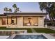 A modern home's backyard boasts a sparkling pool, pristine landscaping, and seamless indoor-outdoor living at 23002 N Country Club Trl, Scottsdale, AZ 85255
