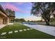 Lush backyard featuring a sparkling pool, artificial turf, and mature trees, creating a private oasis at 23002 N Country Club Trl, Scottsdale, AZ 85255