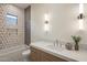Stylish bathroom featuring a tub, decorative tile, a sleek vanity with marble countertop, and modern lighting at 23002 N Country Club Trl, Scottsdale, AZ 85255