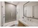 Bathroom featuring walk-in glass shower, herringbone tiling and modern vanity with large mirror at 23002 N Country Club Trl, Scottsdale, AZ 85255