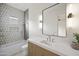 Beautiful bathroom featuring a tub shower combo, unique tiling, modern vanity with sink and a large mirror at 23002 N Country Club Trl, Scottsdale, AZ 85255