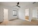 Spacious bedroom with hardwood floors, ceiling fan, and en-suite bathroom, offering ample natural light at 23002 N Country Club Trl, Scottsdale, AZ 85255