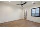 Bright bedroom with hardwood floors, a modern ceiling fan, and large window views at 23002 N Country Club Trl, Scottsdale, AZ 85255