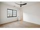 Bright bedroom with hardwood floors, a modern ceiling fan, and large black window frame, offering ample natural light at 23002 N Country Club Trl, Scottsdale, AZ 85255