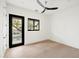 Bedroom featuring wood flooring, modern ceiling fan, black trimmed windows and glass door at 23002 N Country Club Trl, Scottsdale, AZ 85255