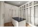 Bright closet with custom shelving, cabinets and center island with dark countertop at 23002 N Country Club Trl, Scottsdale, AZ 85255