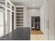 Bright closet with custom shelving, cabinets, island and convenient in-unit washer and dryer at 23002 N Country Club Trl, Scottsdale, AZ 85255