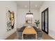 Stylish dining room with a large table, modern chandelier, and unique artwork at 23002 N Country Club Trl, Scottsdale, AZ 85255