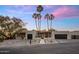 Stunning exterior view of home with palm trees, a terra cotta roof, and three-car garage at 23002 N Country Club Trl, Scottsdale, AZ 85255