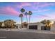 Stunning exterior showcasing a modern home with palm trees, a driveway, and a well-manicured front yard at 23002 N Country Club Trl, Scottsdale, AZ 85255