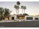 Stunning exterior elevation features palm trees, a red tile roof, and multiple dark-stained garage doors at 23002 N Country Club Trl, Scottsdale, AZ 85255