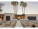 Beautiful exterior elevation with a desert landscape, tile roof, and custom-stained garage doors at 23002 N Country Club Trl, Scottsdale, AZ 85255