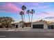 Beautiful exterior of a modern home with desert landscaping, palm trees, and a driveway, offering curb appeal at 23002 N Country Club Trl, Scottsdale, AZ 85255