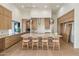 Bright kitchen features an oversized center island, barstool seating, and light wood cabinets at 23002 N Country Club Trl, Scottsdale, AZ 85255