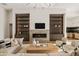 Spacious living room boasts custom built-ins and a fireplace, seamlessly connecting to the kitchen at 23002 N Country Club Trl, Scottsdale, AZ 85255