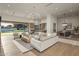 Bright open-concept living space features a modern chandelier, light wood floors, and seamless indoor-outdoor living at 23002 N Country Club Trl, Scottsdale, AZ 85255