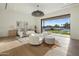 Serene main bedroom boasts natural light, light wood floors, seating area, and direct access to outdoor views at 23002 N Country Club Trl, Scottsdale, AZ 85255