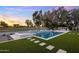 Backyard oasis featuring a sparkling pool and spa, surrounded by lush landscaping and golf course views at 23002 N Country Club Trl, Scottsdale, AZ 85255