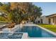 Outdoor living area with a stunning pool, waterfall features, barbecue area, and lush backyard at 23002 N Country Club Trl, Scottsdale, AZ 85255