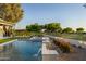 Beautiful swimming pool with water features, landscaping, and views of the golf course at 23002 N Country Club Trl, Scottsdale, AZ 85255