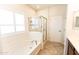 Bright bathroom featuring a glass shower, soaking tub, and plantation shutters at 25640 N 108Th Dr, Peoria, AZ 85383