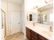 Bright bathroom featuring double sinks, a glass shower, and a view of the water closet at 25640 N 108Th Dr, Peoria, AZ 85383
