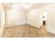 Neutral primary bedroom with tile flooring, ample light, and a view into the ensuite bathroom at 25640 N 108Th Dr, Peoria, AZ 85383