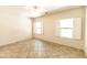 Bright bedroom with tile flooring, two shuttered windows, and neutral paint at 25640 N 108Th Dr, Peoria, AZ 85383